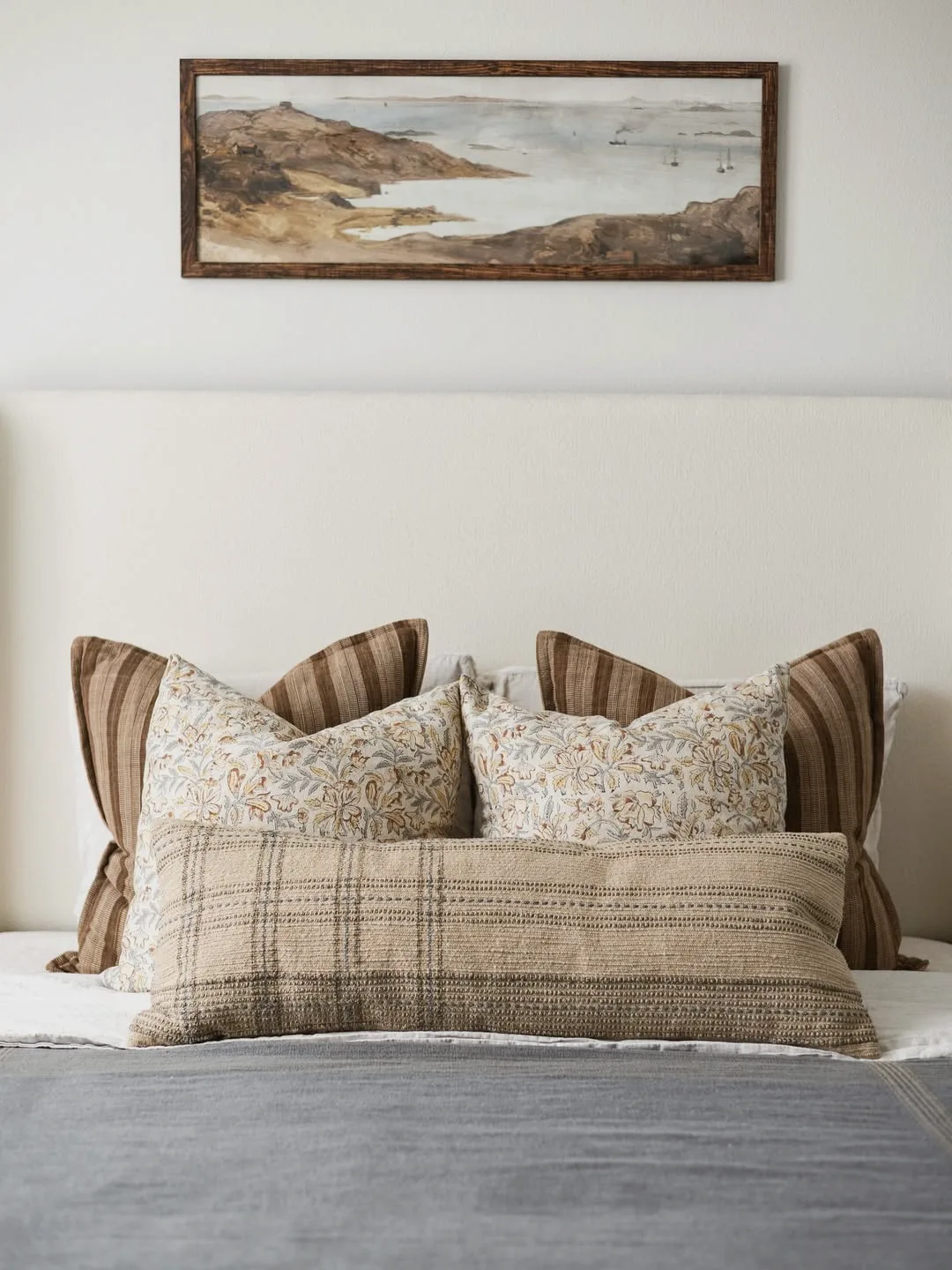 Styled bed with framed coastal artwork