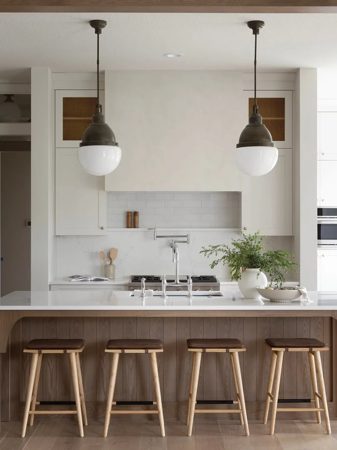 Kitchen island with brass pendant lighting and barstools